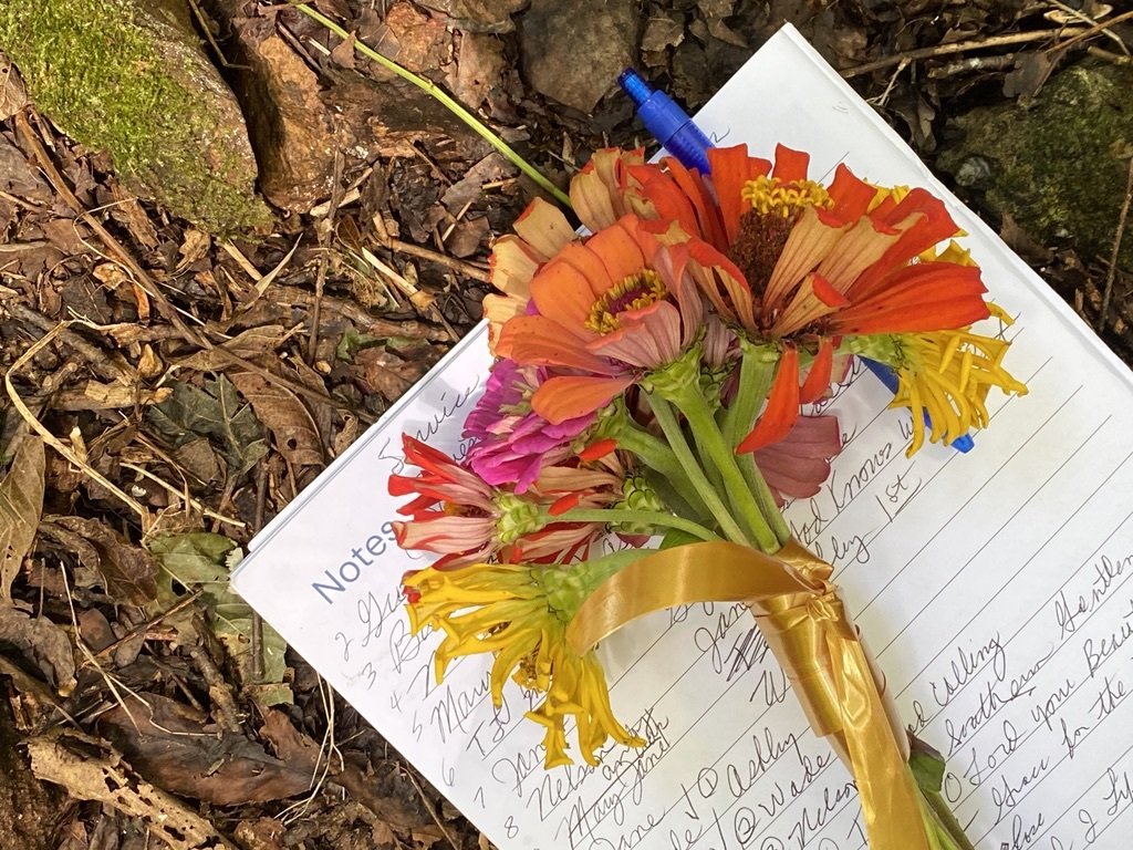  Orange funeral flowers resting on notepad 