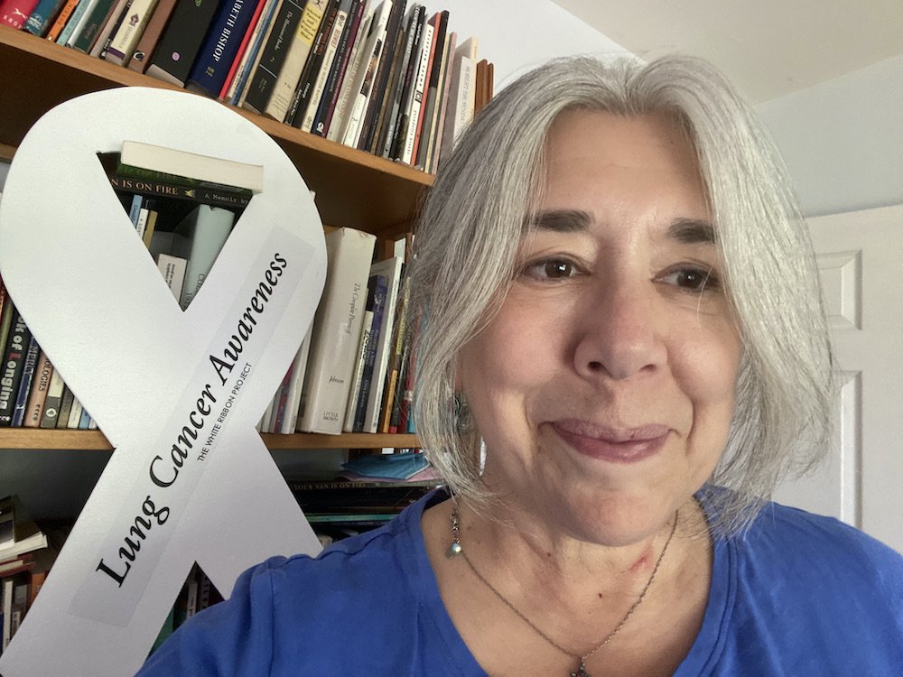Leslie LaChance in front of banner for “Lung Cancer Awareness”