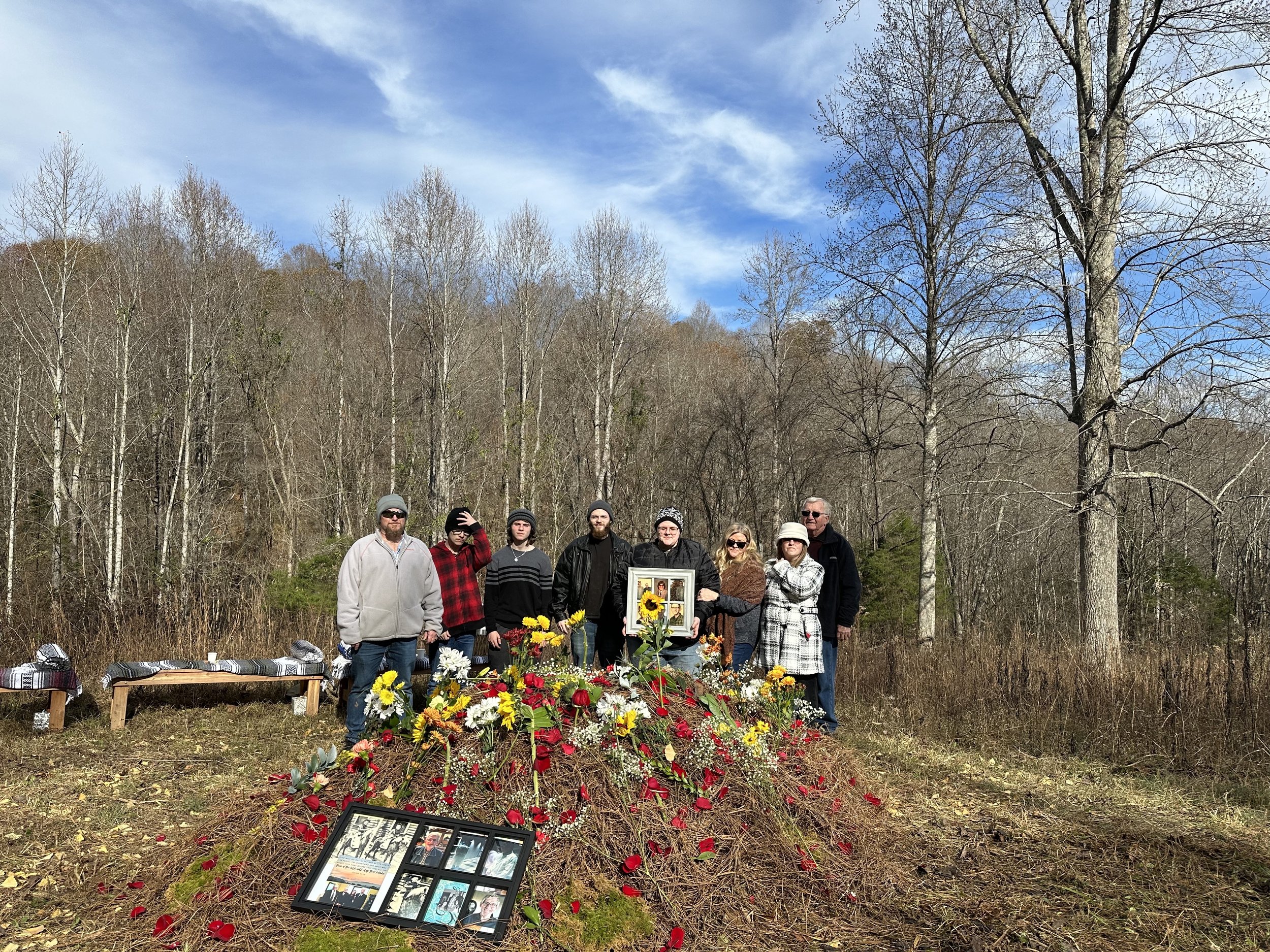  A family stands behind the grave of their loved one after a small funeral at Larkspur Conservation 