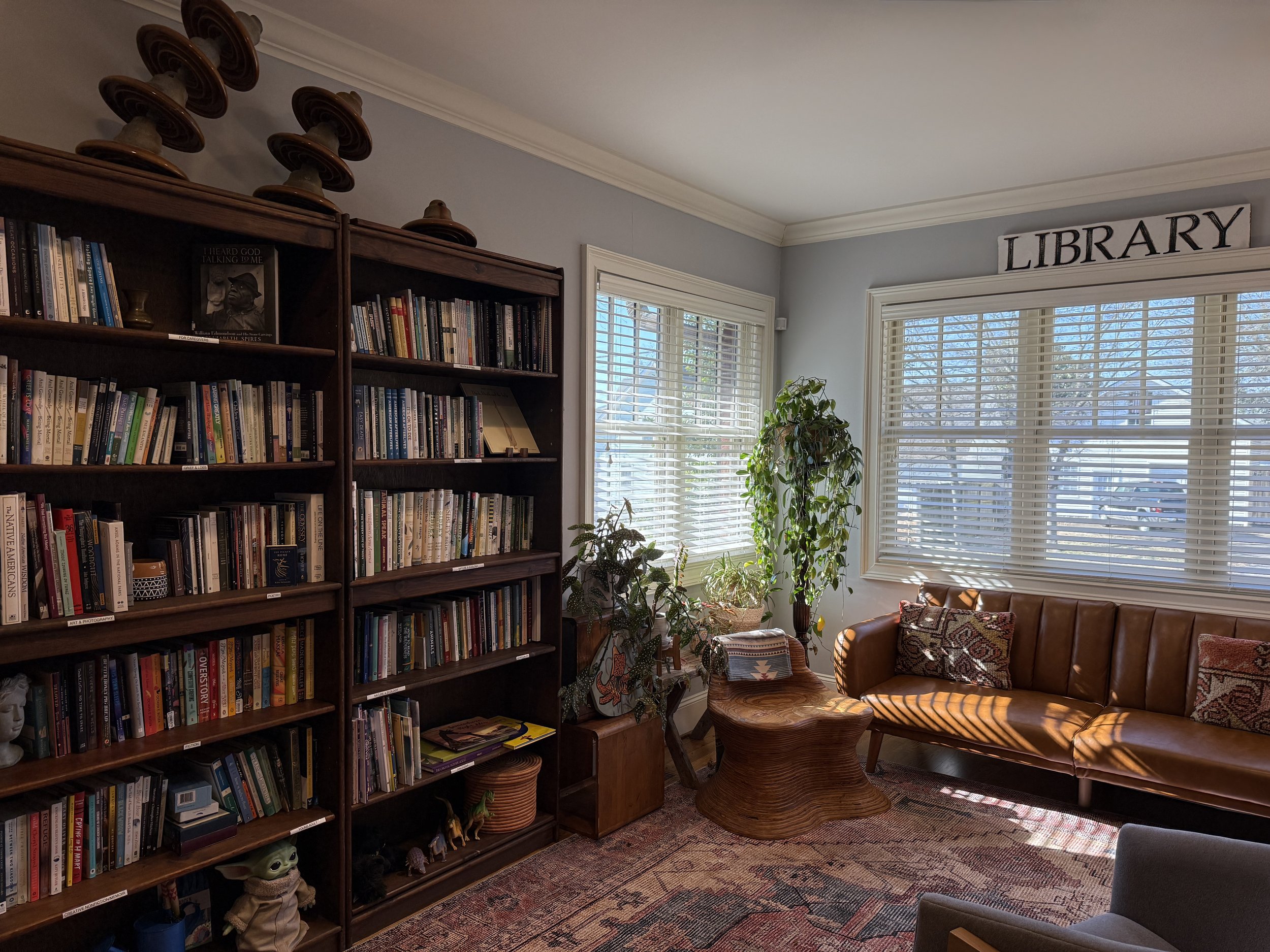  Larkspur’s library, where our community events take place, is filled with shelves of books, a cozy couch, and lots of natural light that streams in through the window to warm the space. 