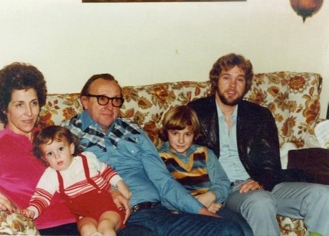  Three generations of family sits on a couch together sharing memories 